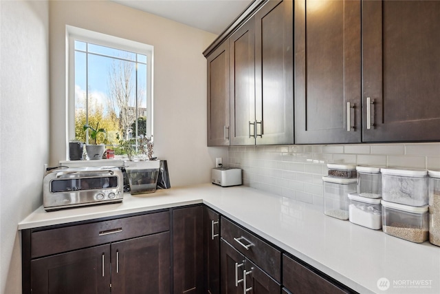 interior space featuring light countertops, plenty of natural light, backsplash, and dark brown cabinetry