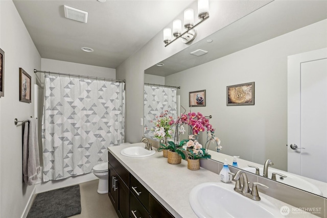 full bathroom featuring toilet, double vanity, a sink, and visible vents