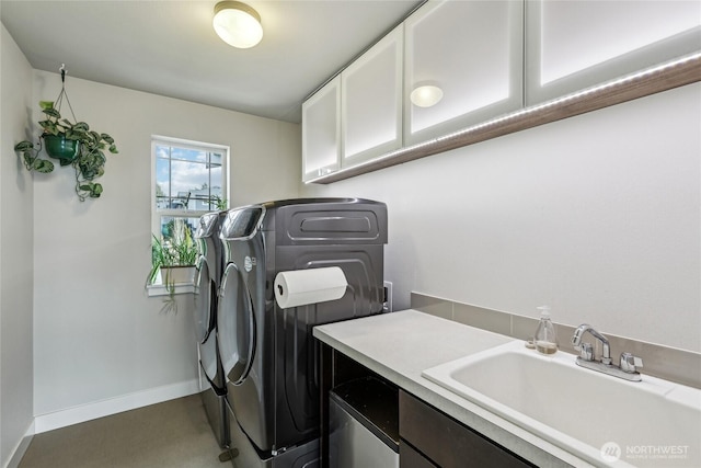 laundry room with washer and dryer, cabinet space, a sink, and baseboards