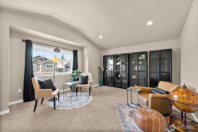 living area featuring vaulted ceiling and carpet