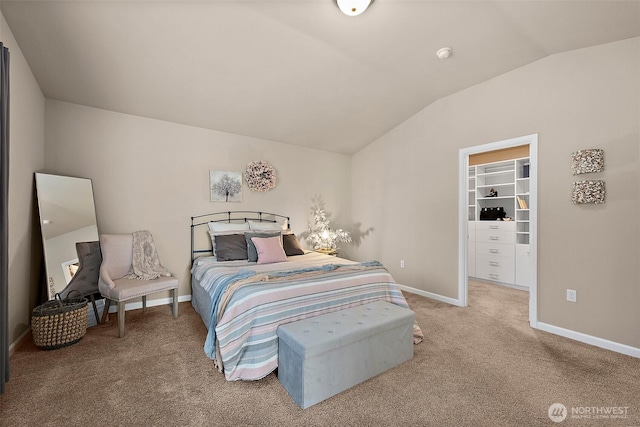 bedroom featuring vaulted ceiling, carpet flooring, and a spacious closet