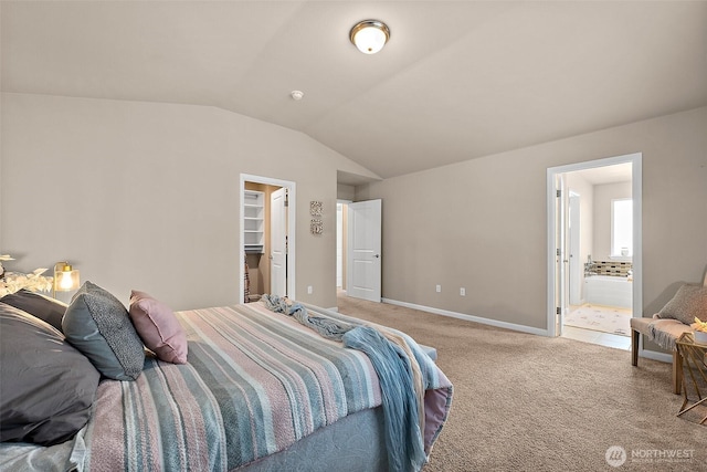 carpeted bedroom with lofted ceiling, a spacious closet, and connected bathroom