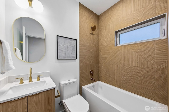 full bathroom featuring vanity, tiled shower / bath, and toilet