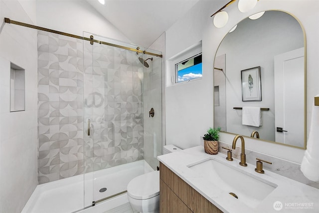 bathroom featuring vanity, vaulted ceiling, toilet, and walk in shower