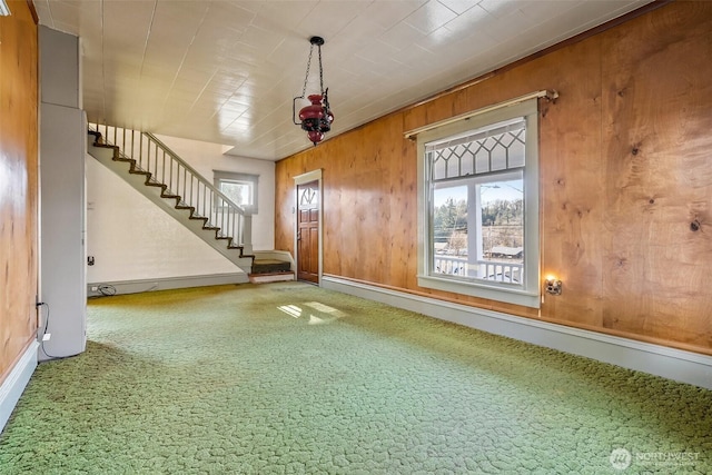 interior space featuring carpet and wood walls