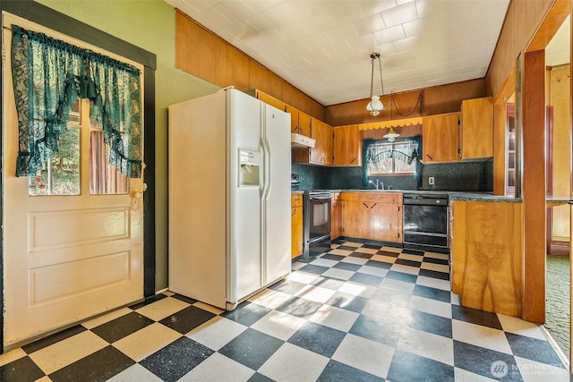 kitchen featuring backsplash, decorative light fixtures, black appliances, and sink