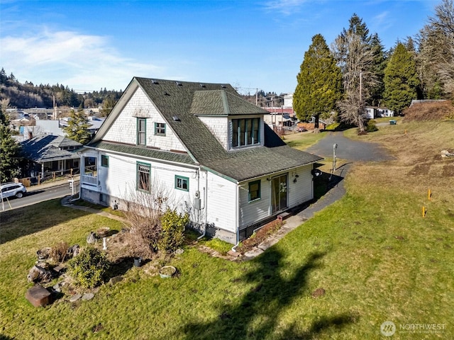 rear view of property featuring a lawn