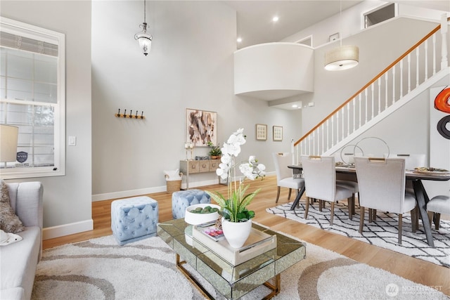 living room with a high ceiling and light hardwood / wood-style flooring