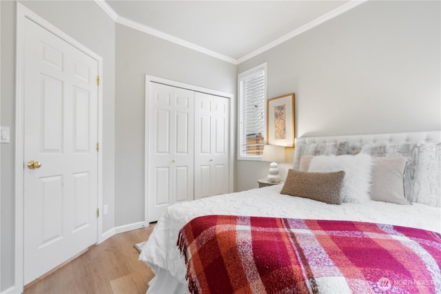 bedroom featuring light hardwood / wood-style floors, a closet, and crown molding