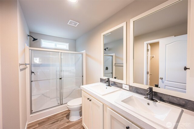 full bath with a stall shower, visible vents, a sink, and toilet