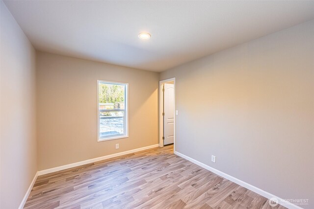 empty room with baseboards and light wood finished floors