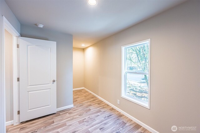 empty room with recessed lighting, light wood-style flooring, and baseboards