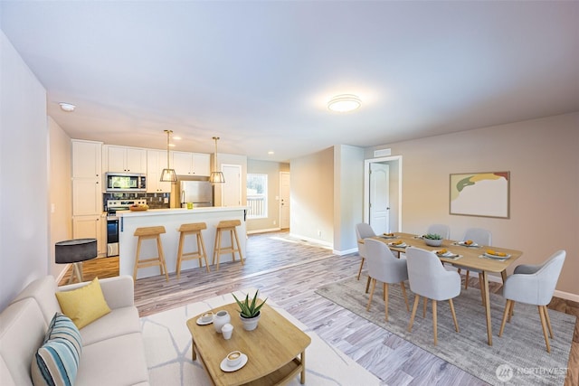 living room featuring light wood-style flooring and baseboards