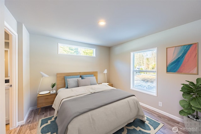 bedroom with light wood-type flooring and baseboards