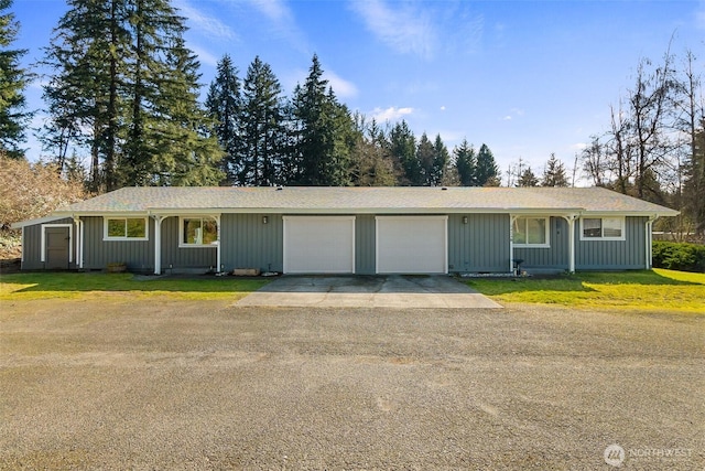 ranch-style house featuring a front yard, a garage, and driveway