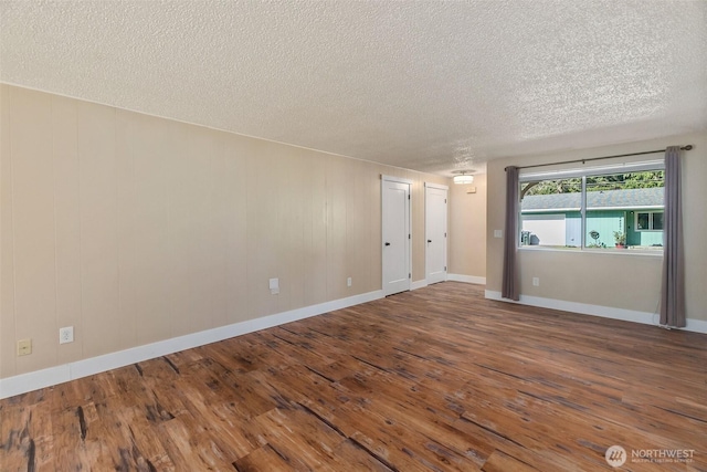 unfurnished room with hardwood / wood-style floors, baseboards, and a textured ceiling