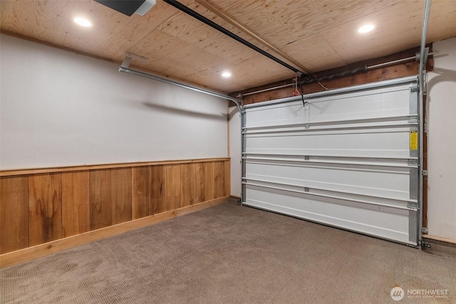 garage featuring recessed lighting, a wainscoted wall, and wooden walls