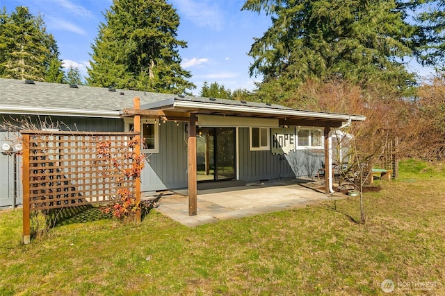 rear view of property with a patio area, a lawn, and board and batten siding