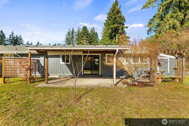 back of property featuring a lawn, board and batten siding, and a patio area