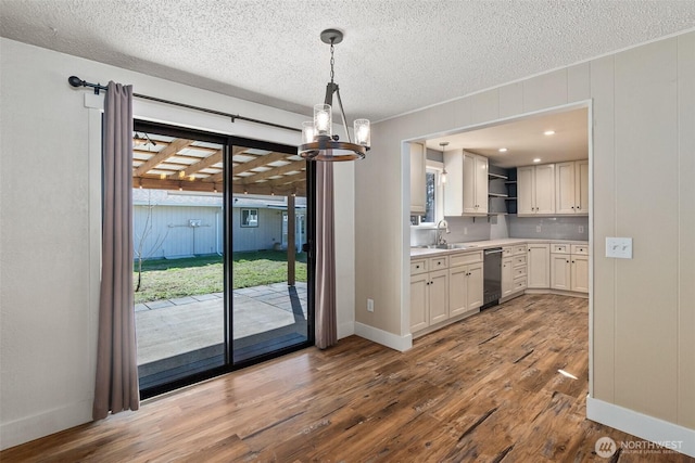 kitchen featuring wood finished floors, open shelves, a sink, light countertops, and white cabinetry