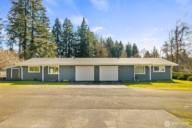 ranch-style house featuring aphalt driveway, a front yard, and an attached garage