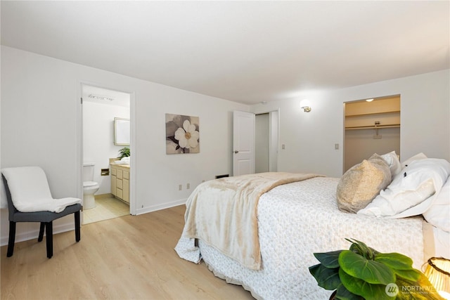 3710 25th Pl W Unit 401, Seattle, WA 98199 - bedroom featuring light wood-type flooring, connected bathroom, and baseboards