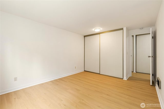 3710 25th Pl W Unit 401, Seattle, WA 98199 - unfurnished bedroom featuring light wood-style floors, baseboards, and a closet