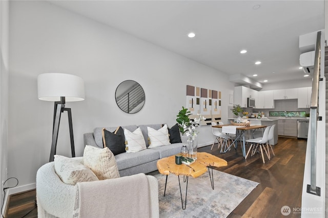 living room featuring sink, dark hardwood / wood-style floors, and a wall mounted AC