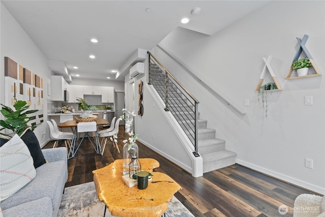 living room with a wall mounted air conditioner and dark hardwood / wood-style flooring