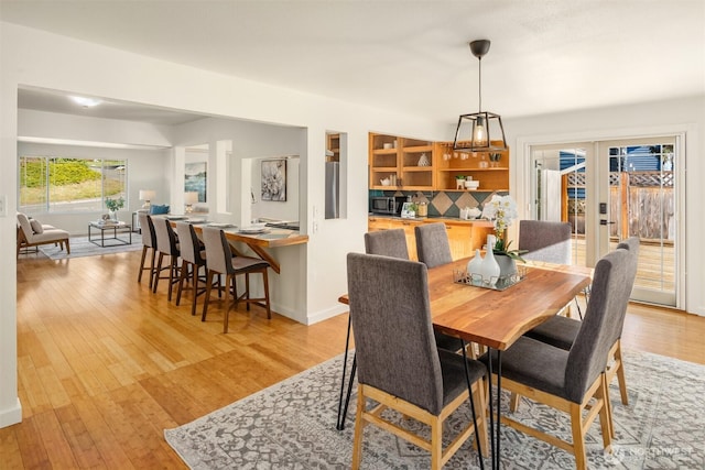 dining area featuring light wood-type flooring and french doors