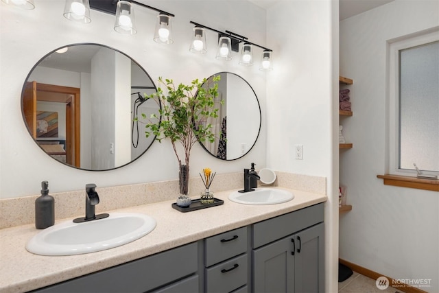 bathroom featuring double vanity, baseboards, and a sink