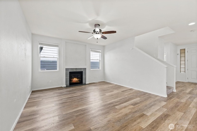 5401 Parkside Dr SE, Lacey, WA 98503 - unfurnished living room with ceiling fan, stairway, light wood finished floors, and a tiled fireplace