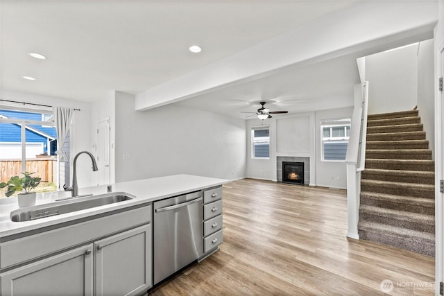 5401 Parkside Dr SE, Lacey, WA 98503 - kitchen featuring dishwasher, a ceiling fan, a tile fireplace, light countertops, and light wood-type flooring
