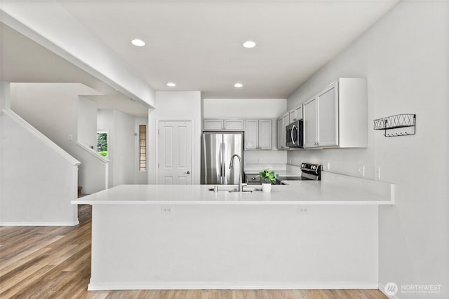 5401 Parkside Dr SE, Lacey, WA 98503 - kitchen featuring stainless steel appliances, a peninsula, light countertops, recessed lighting, and light wood-style floors