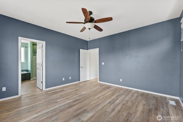 5401 Parkside Dr SE, Lacey, WA 98503 - unfurnished bedroom with wood finished floors, connected bathroom, and ceiling fan