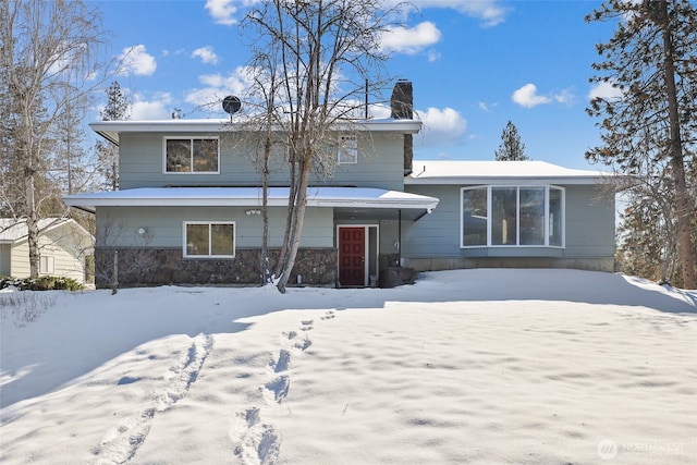 view of snow covered back of property