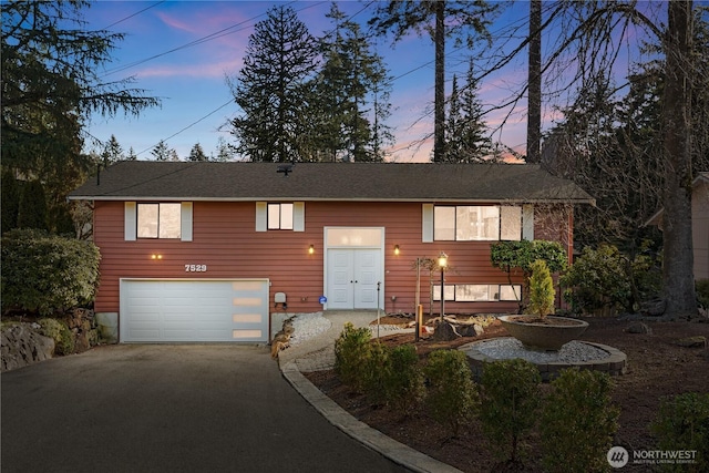 split foyer home with an attached garage and driveway