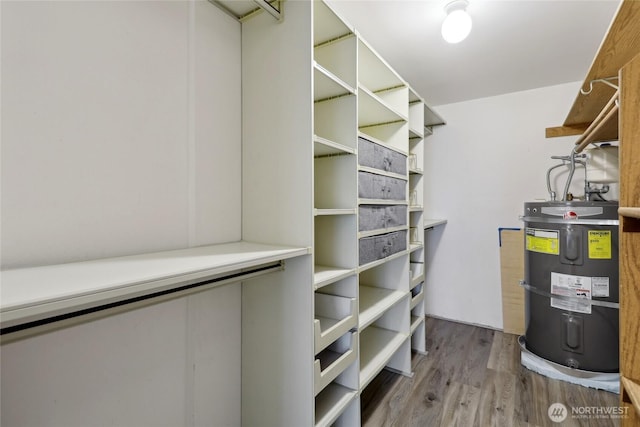 spacious closet with secured water heater and wood finished floors