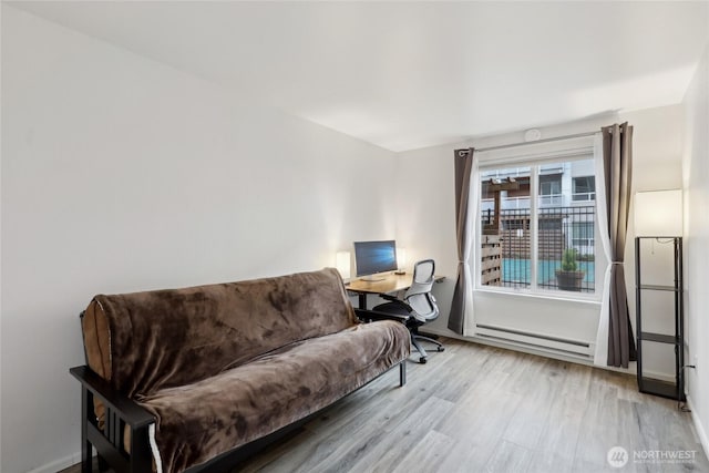 sitting room featuring light wood finished floors, baseboards, and baseboard heating