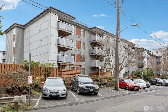 view of property featuring uncovered parking and fence