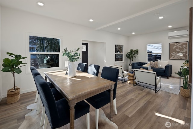 dining room with beamed ceiling, wood-type flooring, and a wall mounted AC