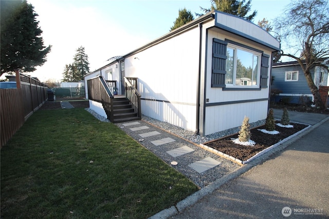 view of side of home with a yard