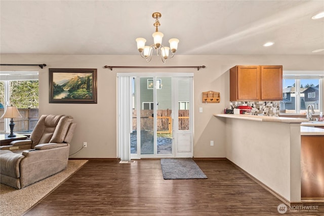 doorway featuring dark hardwood / wood-style flooring, sink, plenty of natural light, and an inviting chandelier