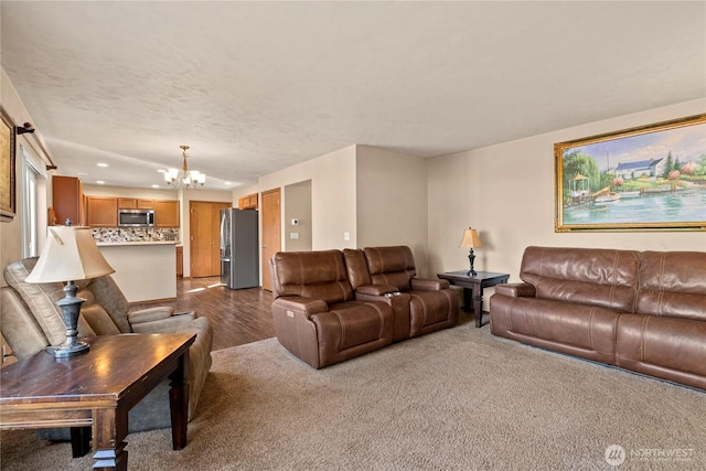 living room with an inviting chandelier, light hardwood / wood-style flooring, and a textured ceiling