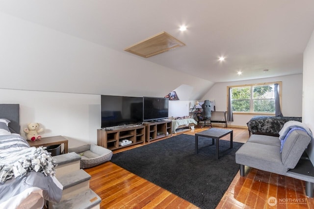 living room featuring wood-type flooring and vaulted ceiling