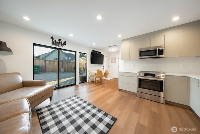 kitchen featuring stainless steel appliances, tasteful backsplash, and light hardwood / wood-style flooring