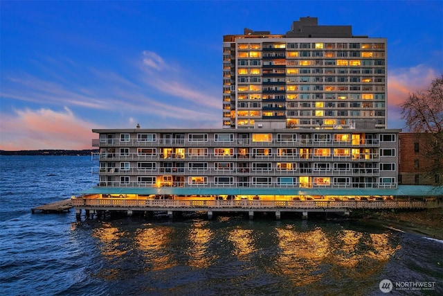 property at dusk featuring a water view