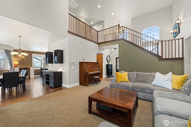 living room with dark carpet, a high ceiling, and a notable chandelier