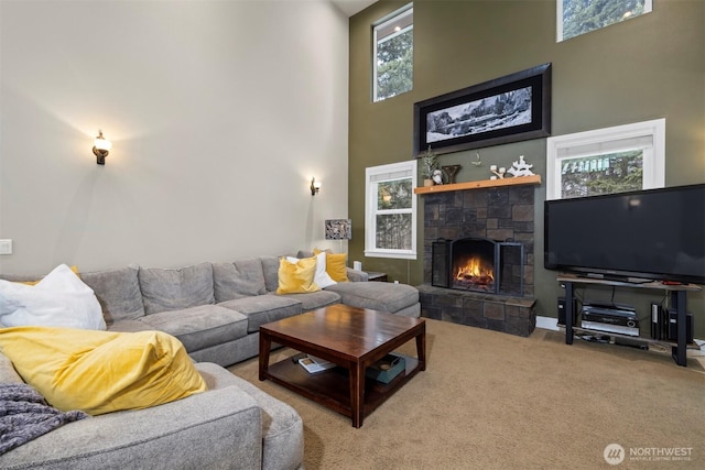 living room with carpet, a towering ceiling, and a fireplace