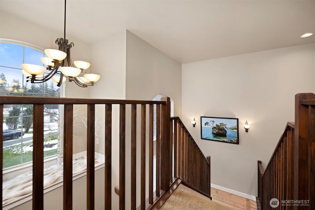 staircase with an inviting chandelier